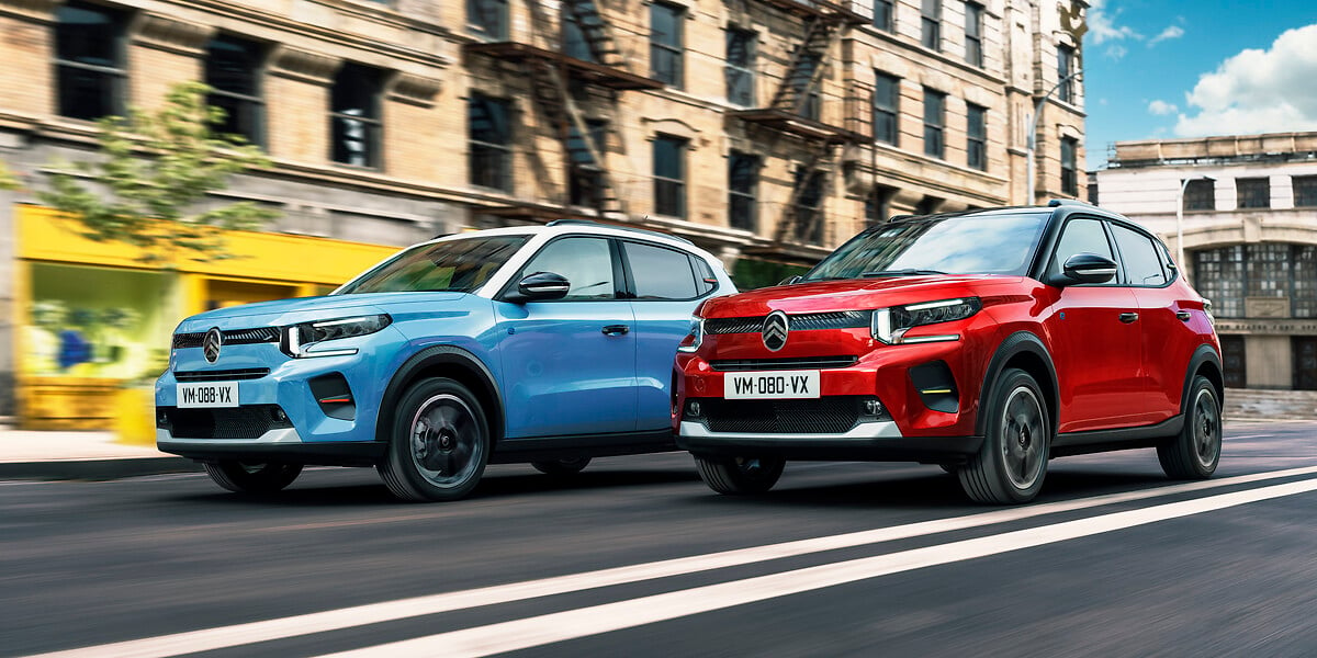 ë-C3, moelo elétrico da Citroën, em suas duas versões, azul e vermelho, andando pela cidade