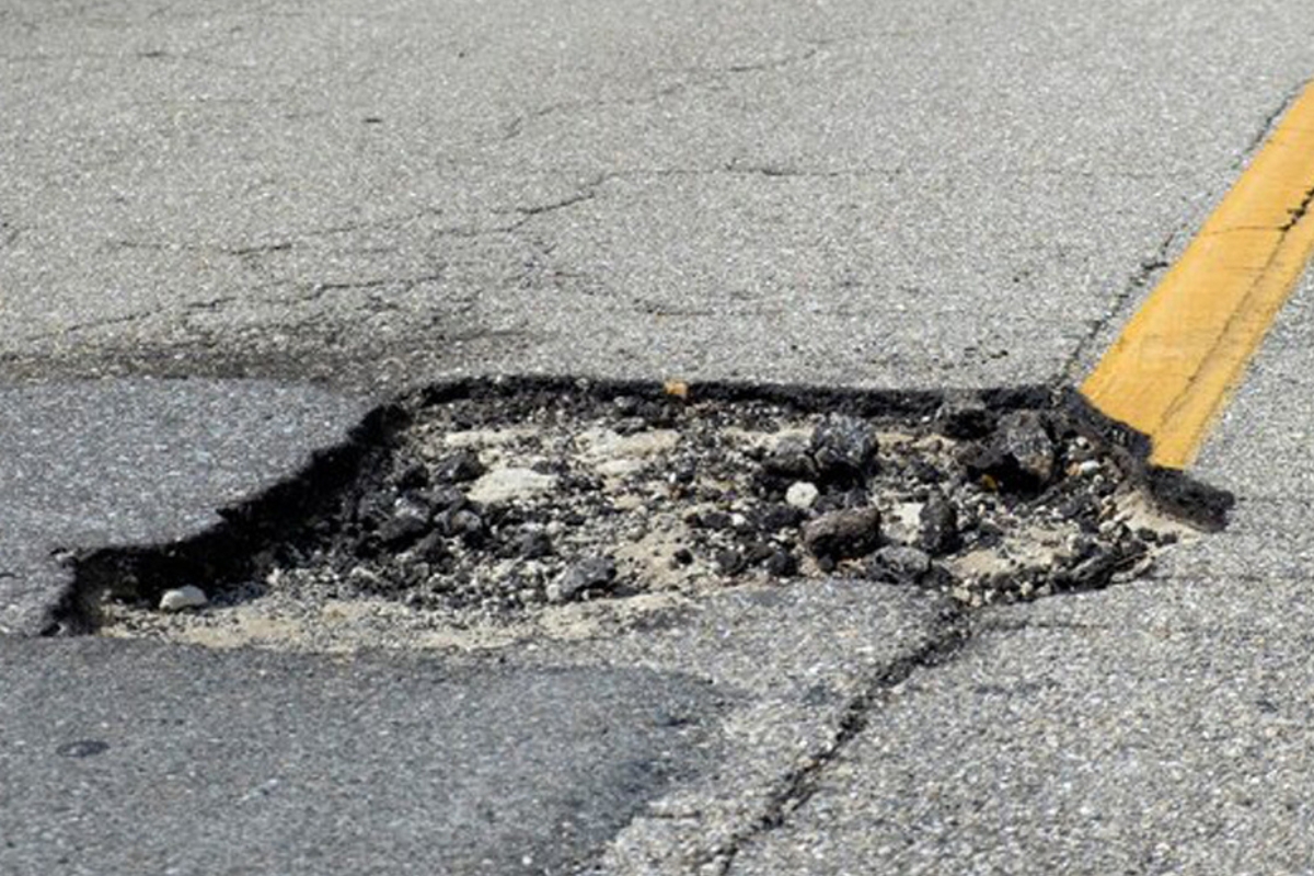 Dirigir com prudência é essencial para lidar com buracos grandes na pista (Foto: Freepik)