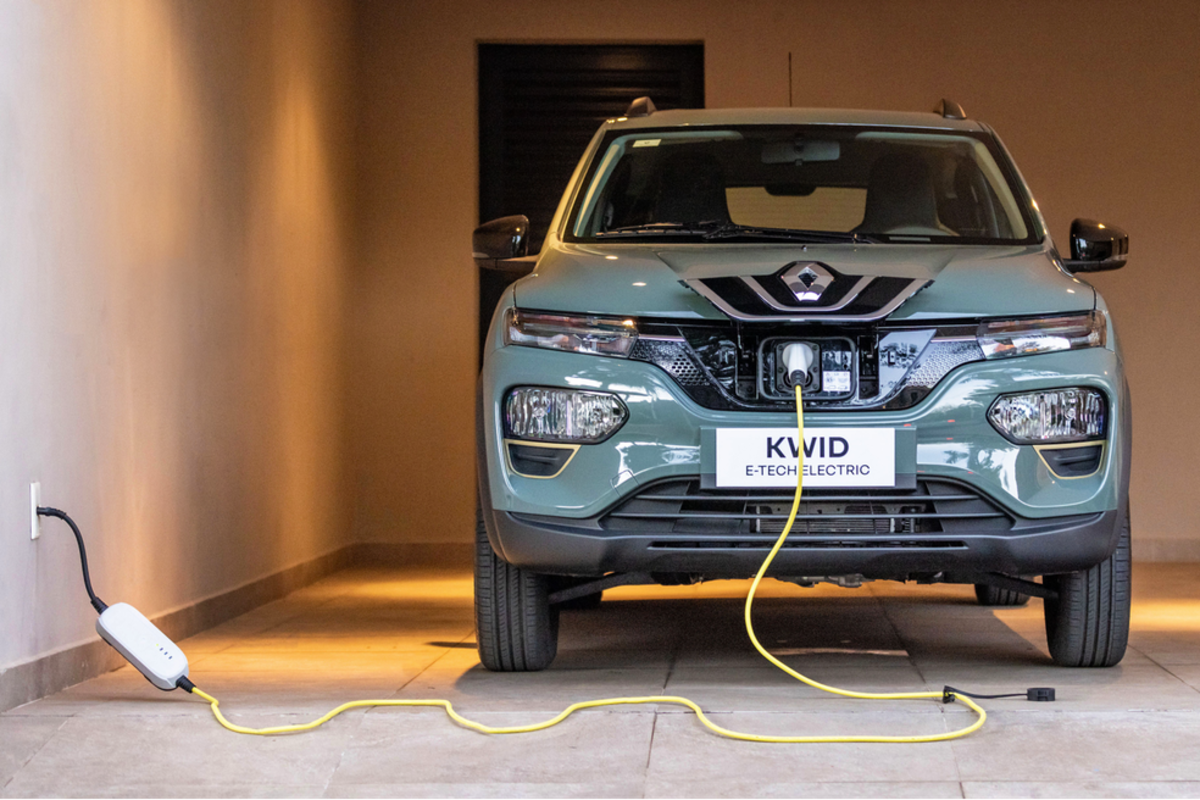 Carro elétrico Renault Kwid E-Tech conectado à uma tomada doméstica para recarga