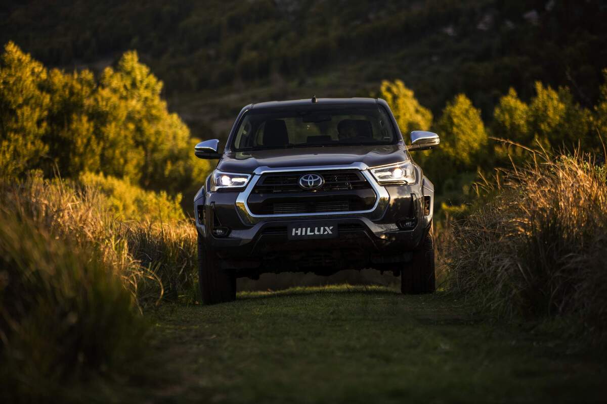 Carro picape Toyota Hilux SRX Plus vista de frente em meio à vegetação