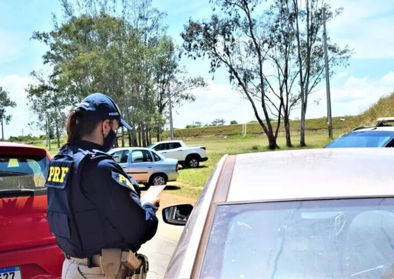 Policial da PRF averiguando um carro